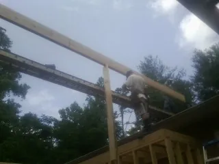Carpenter setting a ridge beam over a new addition frame — Ice Dam Removal by Roofing Brothers in Algodones