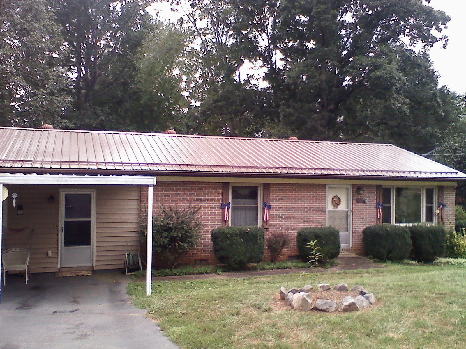 Bronze metal roof and carport on a brick ranch home — Roof Repair work by our crew in Algodones